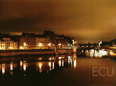 Color photograph taken at night from Pont Louis Philippe over the Seine and the Ile de la Cit&eacute;